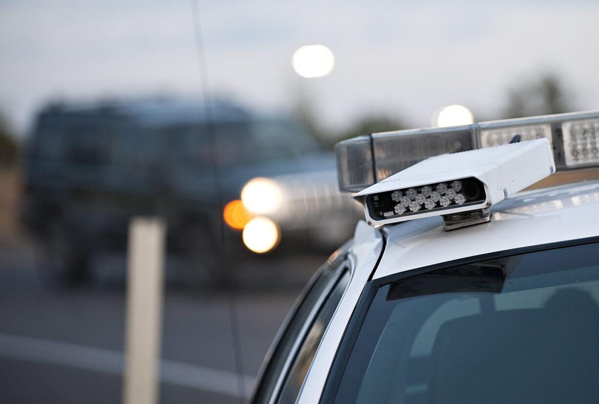 A camera computer system mounted to the top of Washington State Patrol Trooper Steve Schatzel's patrol car helps alert him Tuesday morning to drivers who may not have licensed their vehicles in Washington.