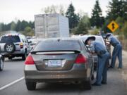 Sgt. Jason Cuthbert, foreground, talks Tuesday morning with a driver suspected of not licensing the car in Washington along the Mill Plain Boulevard onramp to Interstate 205 southbound.