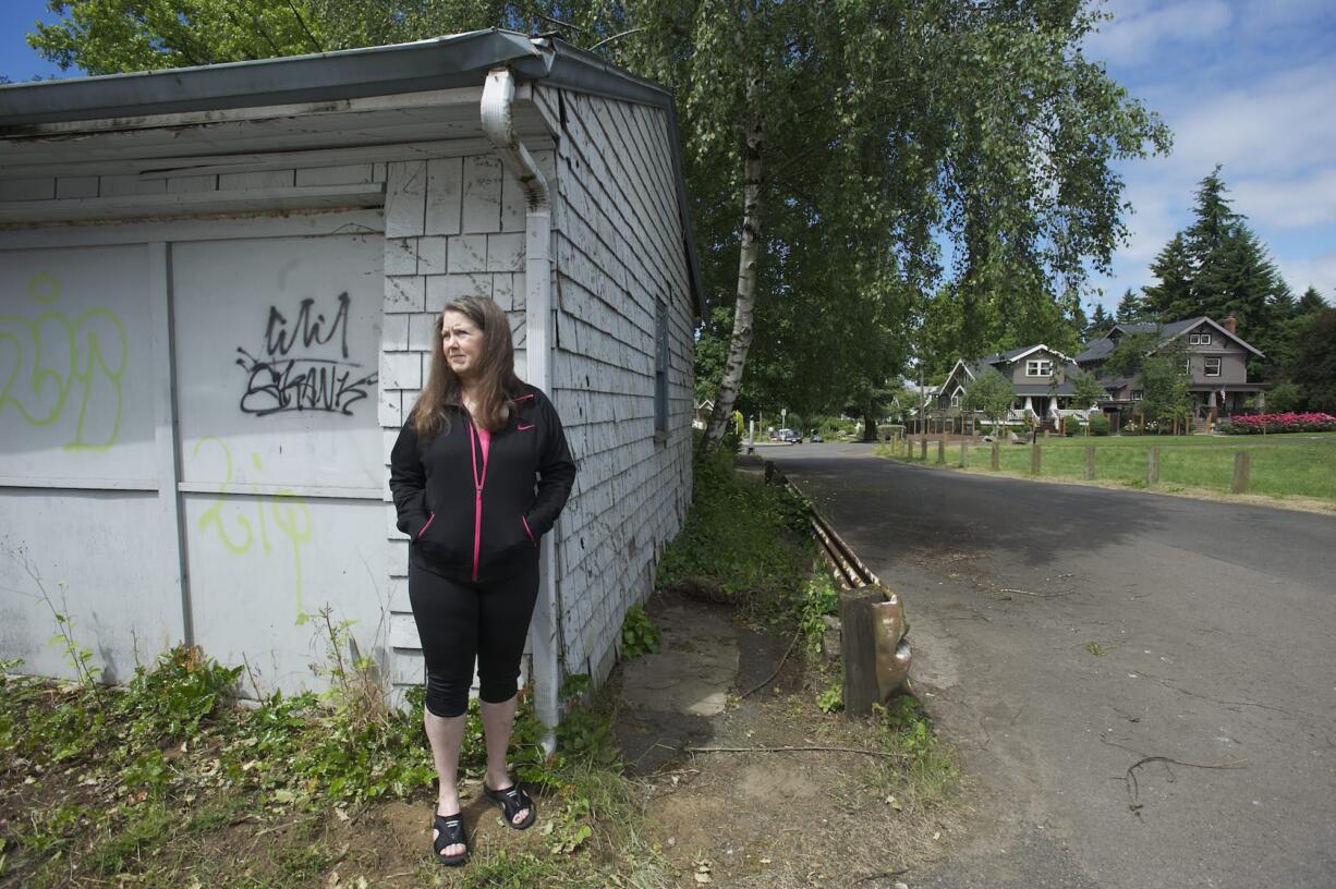 Suze Marshall poses for a portrait next to her garage in June.