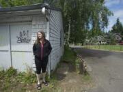 Suze Marshall poses for a portrait next to her garage in June.