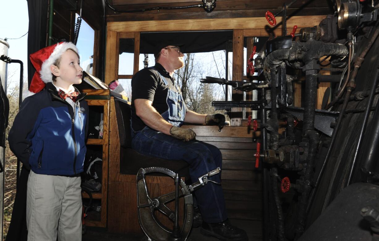 Joey Douglas, 9, left, the youngest docent with the Oregon Rail Heritage Center, with fireman Matt Baccitich, rides in the cab of the Spokane Portland