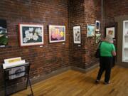 A visitor walks through Gallery 360's Art in the Heart exhibit earlier this month, the second-to-last art show at the Ninth Street location before the gallery closes in early September.