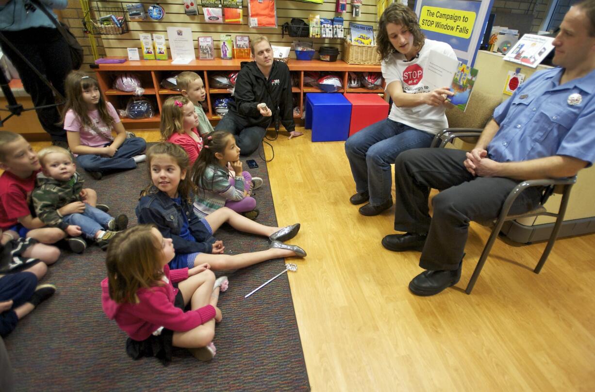 Becca Keen Cunningham of Vancouver, with her husband Jason Keen Cunningham, reads her book, &quot;If Kids Could Float: A Window Fall Prevention Story,&quot; to a group of children Wednesday at Randall Children's Hospital's Safety Center in Portland.