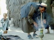 A farmer smokes hashish near the northern Afghan city of Mazar-e-Sharif on Sept. 11, 2002.