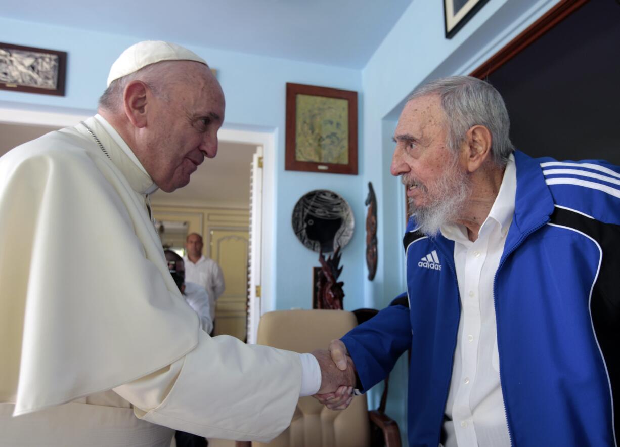 Pope Francis and Cuba's Fidel Castro shakes hands, in Havana, Cuba, Sunday, Sept. 20, 2015. The Vatican described the 40-minute meeting at Castro's residence as informal and familial, with an exchange of books.