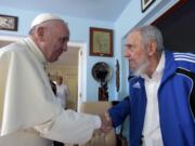 Pope Francis and Cuba's Fidel Castro shakes hands, in Havana, Cuba, Sunday, Sept. 20, 2015. The Vatican described the 40-minute meeting at Castro's residence as informal and familial, with an exchange of books.