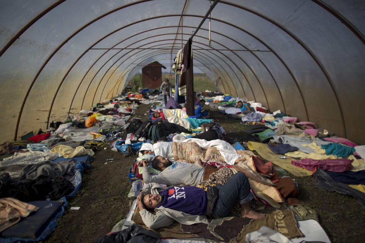 Syrian people sleep inside a greenhouse at a makeshift camp for asylum seekers near Roszke, southern Hungary, Sunday, Sept. 13, 2015. Hundreds of thousands of Syrian refugees and others are still making their way slowly across Europe, seeking shelter where they can, taking a bus or a train where one is available, walking where it isn't.