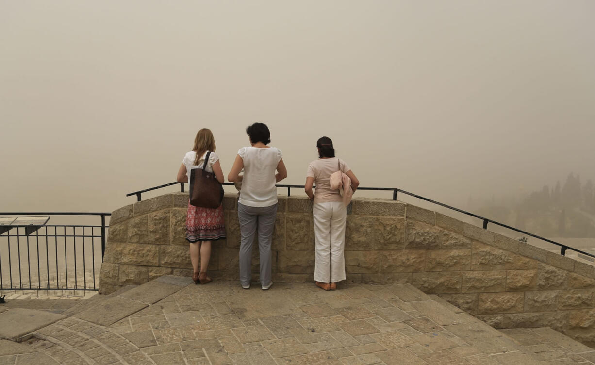 Women view scenery obscured by a sandstorm as they visit Jerusalem's Old City on Tuesday. The unseasonal sandstorm has hit the Middle East, reducing visibility and sending hundreds to hospitals with breathing difficulties.