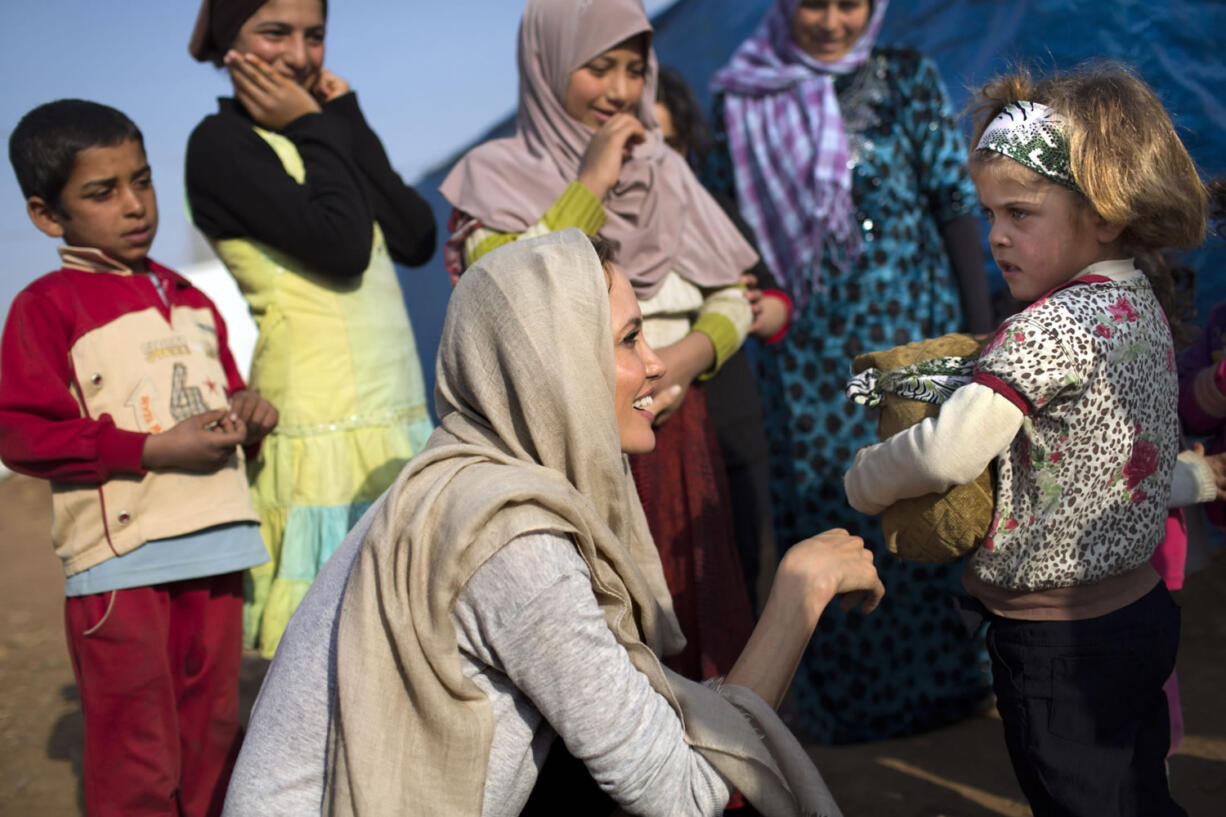 Actress and U.N. special envoy Angelina Jolie, center foreground, meets with young Syrian refugees Sunday at an informal tented settlement in Zahleh, Bekaa Valley, Lebanon.