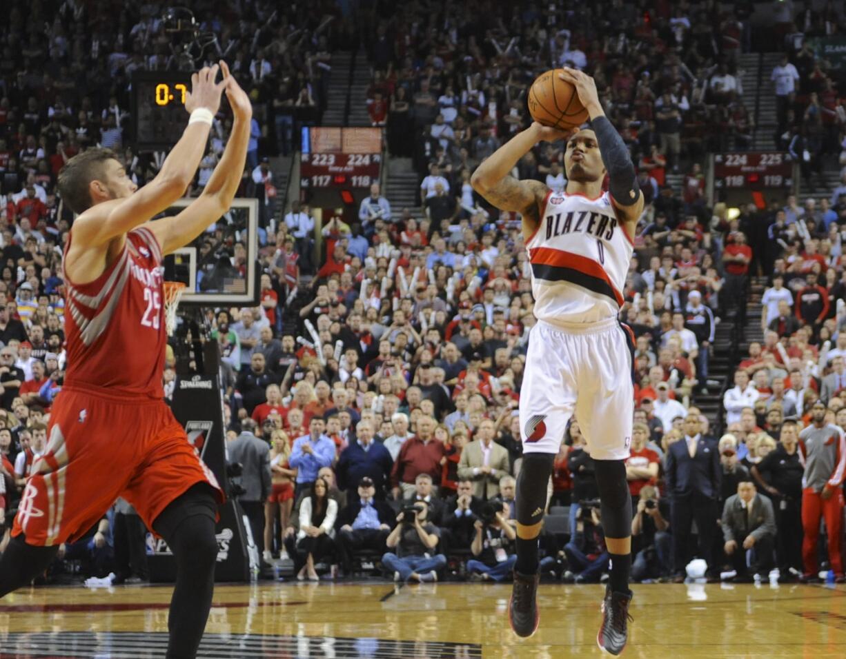 Portland Trail Blazers' Damian Lillard (0) shoots his winning shot against the Houston Rockets during the last .9 of a second of game six of an NBA basketball first-round playoff series game in Portland, Ore., Friday May 2, 2014. The Trail Blazers won the series in a 99-98 win.