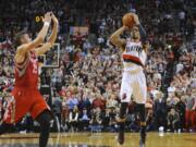 Portland Trail Blazers' Damian Lillard (0) shoots his winning shot against the Houston Rockets during the last .9 of a second of game six of an NBA basketball first-round playoff series game in Portland, Ore., Friday May 2, 2014. The Trail Blazers won the series in a 99-98 win.