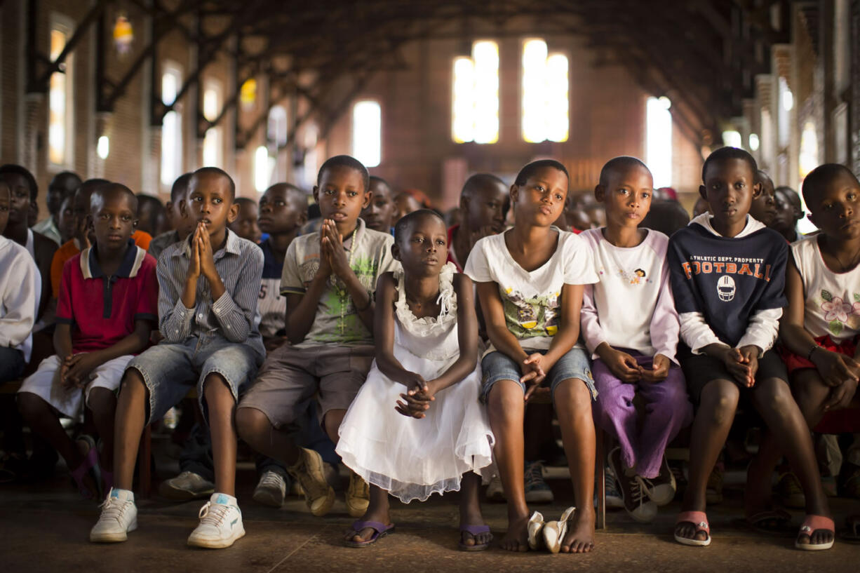 Rwandan children listen and pray during a Sunday service at the Saint-Famille Catholic church, the scene of many killings during the 1994 genocide, in the Rwanda capital of Kigali.