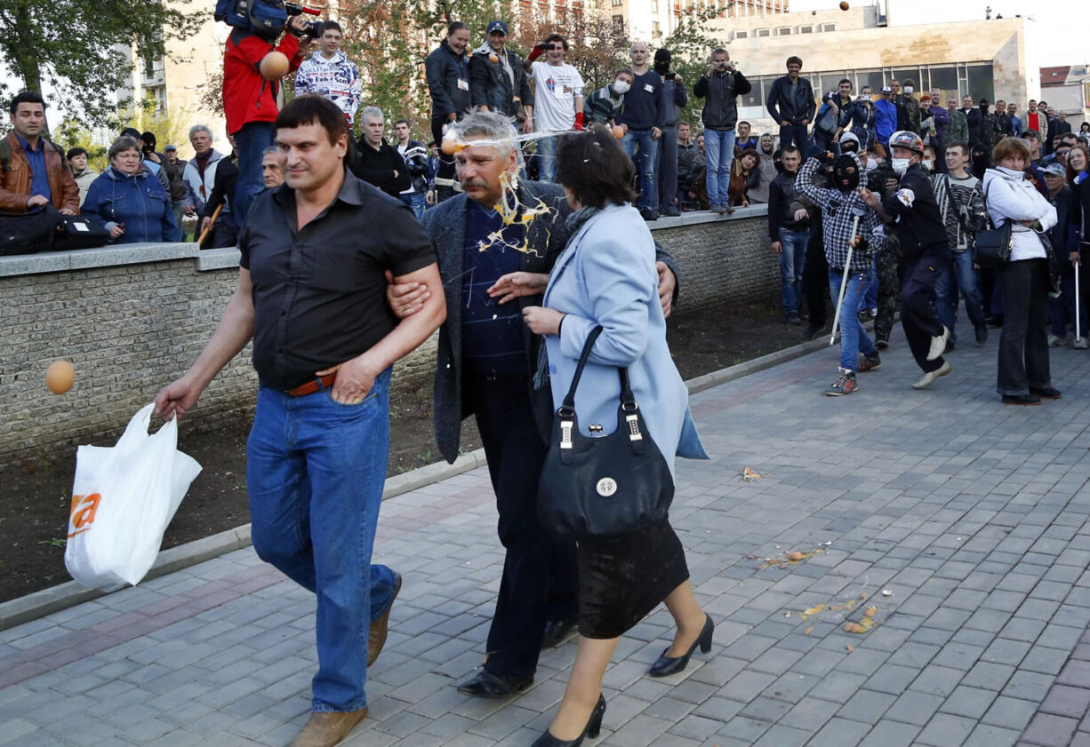 Pro-Russia protestors, right, throw eggs at pro-Ukrainian activists in Donetsk, eastern Ukraine, on Tuesday.