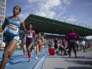 Competitors pass the shot-put area during the women's 1500 meters during the IAAF Diamond League Grand Prix competition on Randall's Island, Saturday in New York.