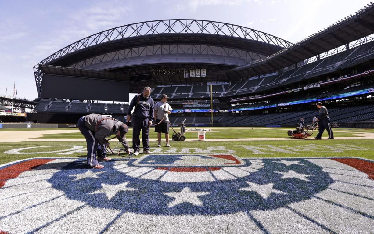 Groundskeepers finish prep work on the Seattle Mariners' field Monday, April 7, 2014, in Seattle. The Mariners, 4-2, open at home Tuesday against the Los Angeles Angels.