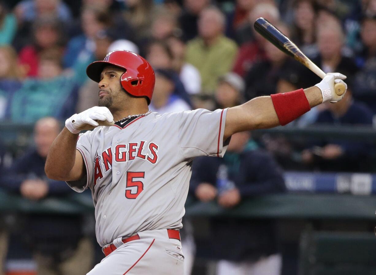 Los Angeles Angels' Albert Pujols watches his two-run home run in the first inning of a baseball game against the Seattle Mariners, Wednesday, April 8, 2015, in Seattle. (AP Photo/Ted S.