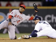 Los Angeles Angels shortstop Erick Aybar (2) and Seattle Mariners' Brad Miller look up for the call on Miller's stolen base at second base in the sixth inning of a baseball game Tuesday, May 27, 2014, in Seattle.