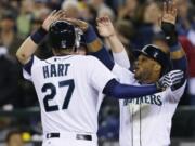 Seattle's Corey Hart (27) is greeted at the plate by Robinson Cano, right, and Justin Smoak after Hart's three-run home run.