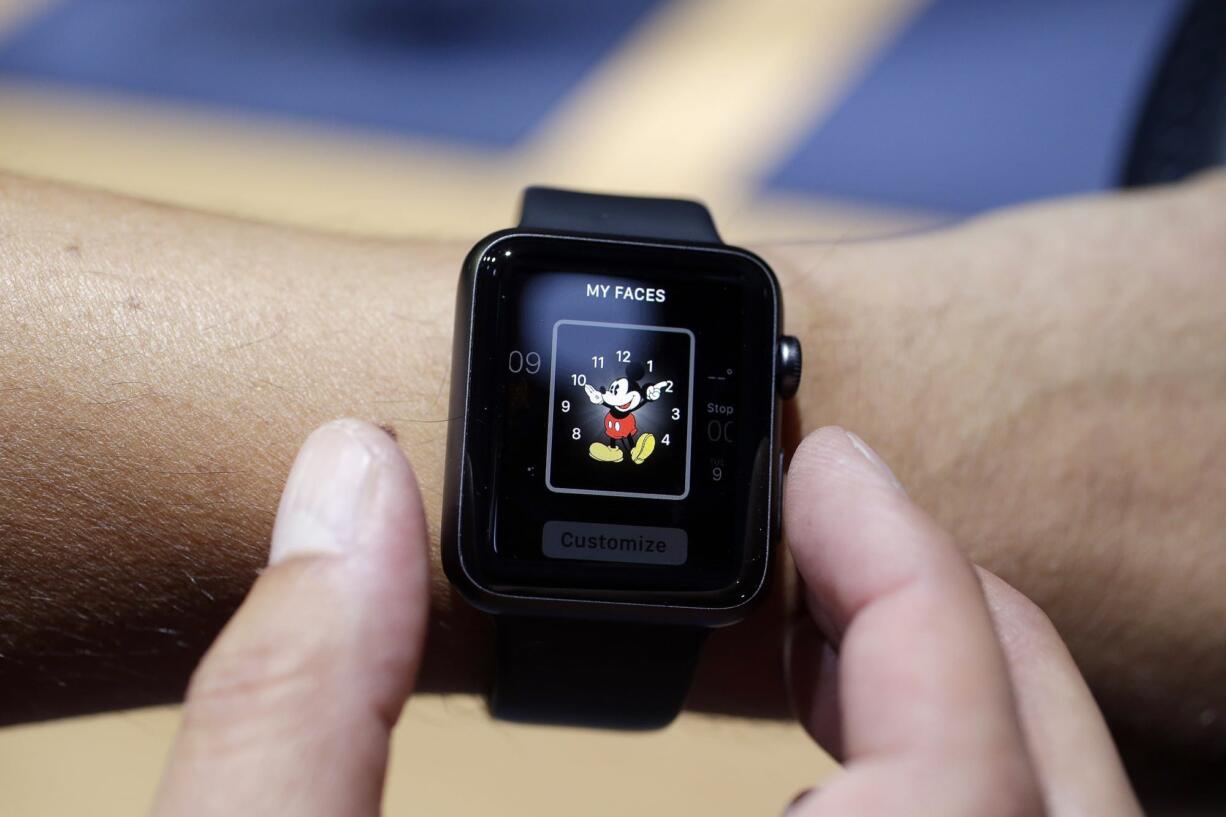 An Apple Watch featuring a Mickey Mouse face is tried out during a September event in Cupertino, Calif. Apple Watch, available for pre-order Friday, comes with a choice of watch case, band and size.