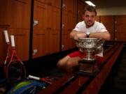 In this photo released by Tennis Australia, Switzerland's Stanislas Wawrinka poses with the championship trophy at the players' locker room after defeating Spain's Rafael Nadal in the men's singles final at the Australian Open tennis championship in Melbourne, Australia, Sunday, Jan. 26, 2014.