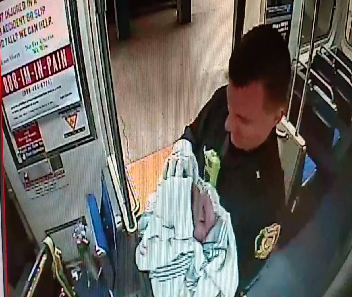 In this image from a Thursday surveillance video provided by the Southeastern Pennsylvania Transportation Authority, Philadelphia transit police Sgt. Daniel Caban holds a baby boy he helped deliver aboard a subway train at the 15th and Market streets station in Philadelphia. The mother and newborn were taken to Hahnemann University Hospital, where they were reported in good condition.