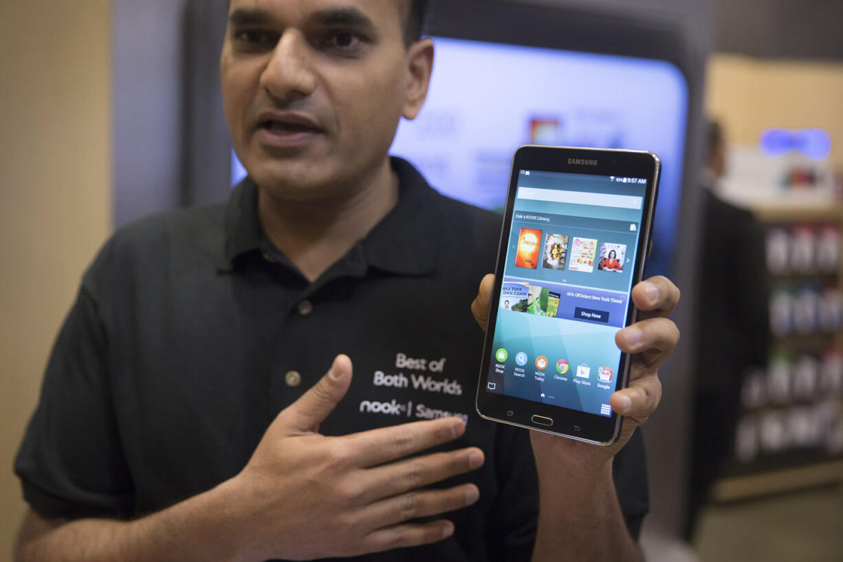 A brand ambassador holds a Samsung Galaxy Tab 4 Nook during the unveiling Wednesday of the co-branded tablet that will replace B