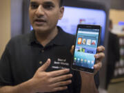 A brand ambassador holds a Samsung Galaxy Tab 4 Nook during the unveiling Wednesday of the co-branded tablet that will replace B