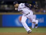 Seattle Mariners second baseman Robinson Cano throws a ball to first base after fielding deflection during the ninth inning a baseball game against the Toronto Blue Jays, Wednesday, Aug. 13, 2014, in Seattle. The Mariners won 2-0.