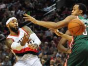 Portland Trail Blazers guard Mo Williams (25) passes the ball around Milwaukee Bucks center John Henson (31) during the second half of an NBA basketball game in Portland, Ore., Tuesday, March 18, 2014. The Blazers won the game 120-115 in overtime.