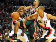 Milwaukee Bucks guard Ramon Sessions (13) has the ball knocked away by Portland Trail Blazers forward Thomas Robinson (41) and guard C.J.