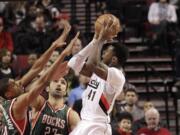 Portland Trail Blazers forward Thomas Robinson, right, shoots against Milwaukee Bucks forward Giannis Antetokounmpo and center Zaza Pachulia.