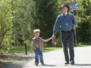 Samuel Eyk and his grandfather, Cal Eyk, stroll along Burnt Bridge Creek Trail in Vancouver on April 15. Samuel was very clear that the pinwheel belonged to him.