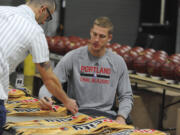 Portland Trail Blazers' Mason Plumlee, right, signs flags during the NBA basketball team media day, Monday, Sept. 28, 2015, in Portland, Ore.