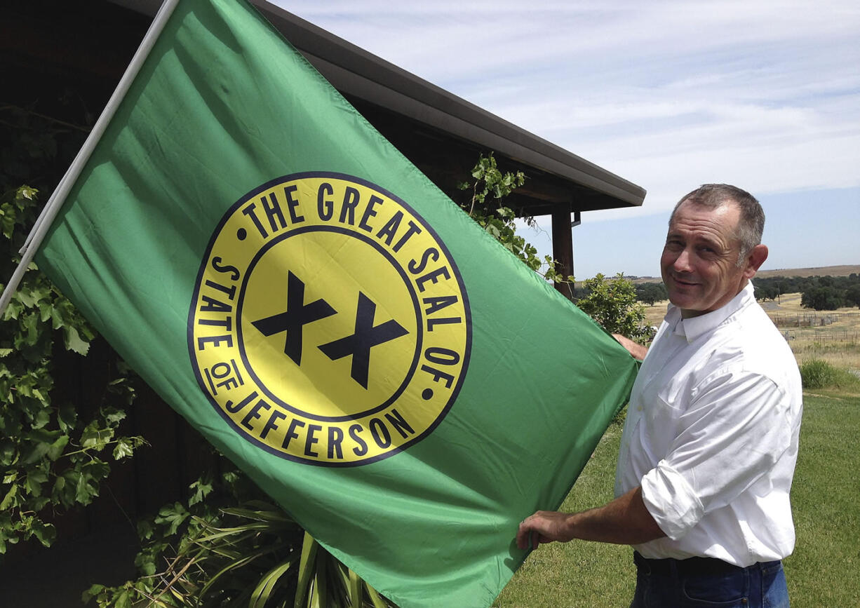 Tom Knorr, chairman of the Measure A campaign in Tehama County, holds a State of Jefferson flag Tuesday at his ranch house in Corning, Calif.