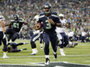 Seattle Seahawks quarterback Russell Wilson runs for a touchdown in the first half of a preseason NFL game against the San Diego Chargers, Friday, Aug. 15, 2014, in Seattle. It was Wilson's second rushing touchdown in the first half.