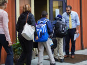 Parents, guardians and students are greeted by Adel Sefrioui, founder and executive director of Excel Public Charter School in Kent as they enter school Tuesda. A national advocacy group is calling on Gov. Jay Inslee to order a special session of the Legislature so lawmakers can change a charter school law declared unconstitutional. The National Alliance for Public Charter Schools said Saturday that nearly 1,200 students will be forced out of their current schools unless lawmakers take action. (Ellen M.