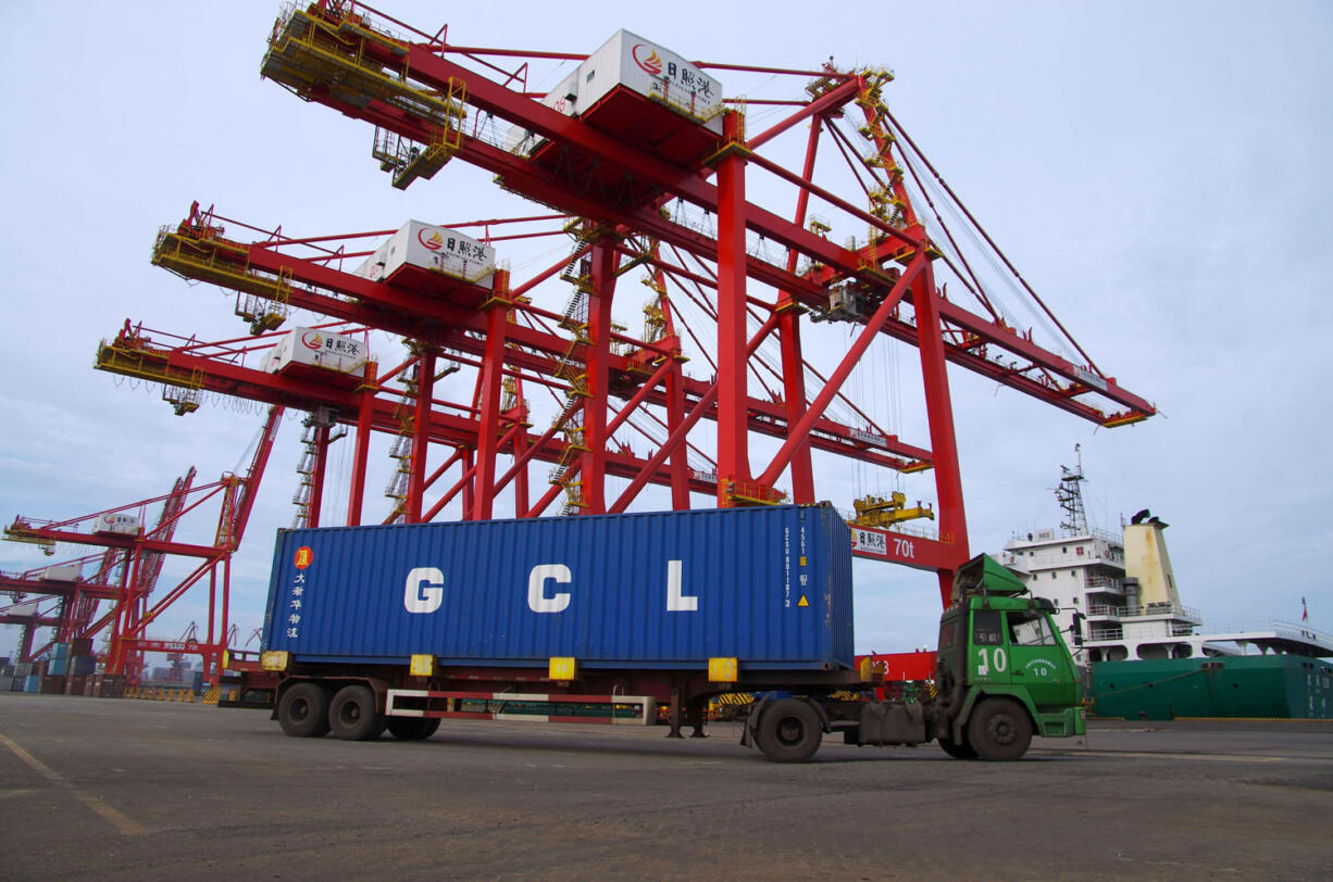 A cargo truck drives through a container port in Rizhao in eastern China's Shandong province. Chinese exports and imports contracted in August, 2015 in the latest sign of weakness for the world's second-biggest economy. Customs data posted online Tuesday, Sept. 8, 2015 showed that shipments of goods last month shrank 5.5 percent in dollar terms compared with a year earlier while imports tumbled by 13.8 percent.