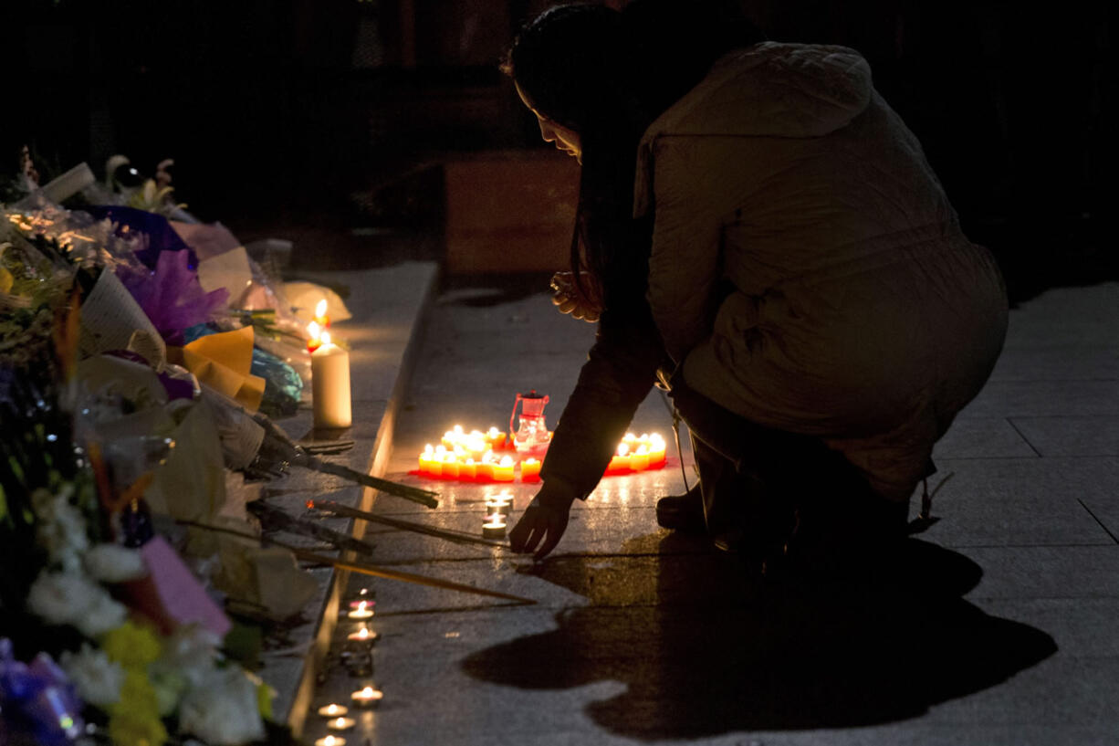 A woman lights incense sticks at the site of a deadly stampede to commemorate the victims in Shanghai, China, on Thursday.