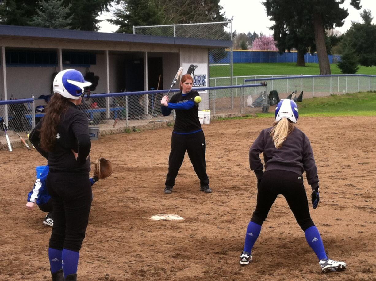 Clark College softball coach Mandy Hill hits a ground ball during a defensive drill Thursday.