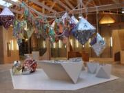 A ConfettiSystem installation features quartz and crystal pinatas and twist rope garlands. ConfettiSystem transforms simple materials such as tissue paper, cardboard, and silk into interactive objects that are filled with hand-cut confetti.