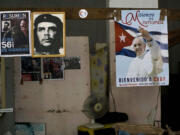 A poster of Pope Francis hangs next to a picture of revolutionary hero Ernesto "Che" Guevara and Fidel Castro inside a state store that sells flour and beans in Havana, Cuba, on Friday. Francis delivered an unprecedented televised message to the Cuban people on Thursday night ahead of a four-day trip to the island.