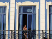 A tourist looks out from his hotel room's balcony in Havana, Cuba.