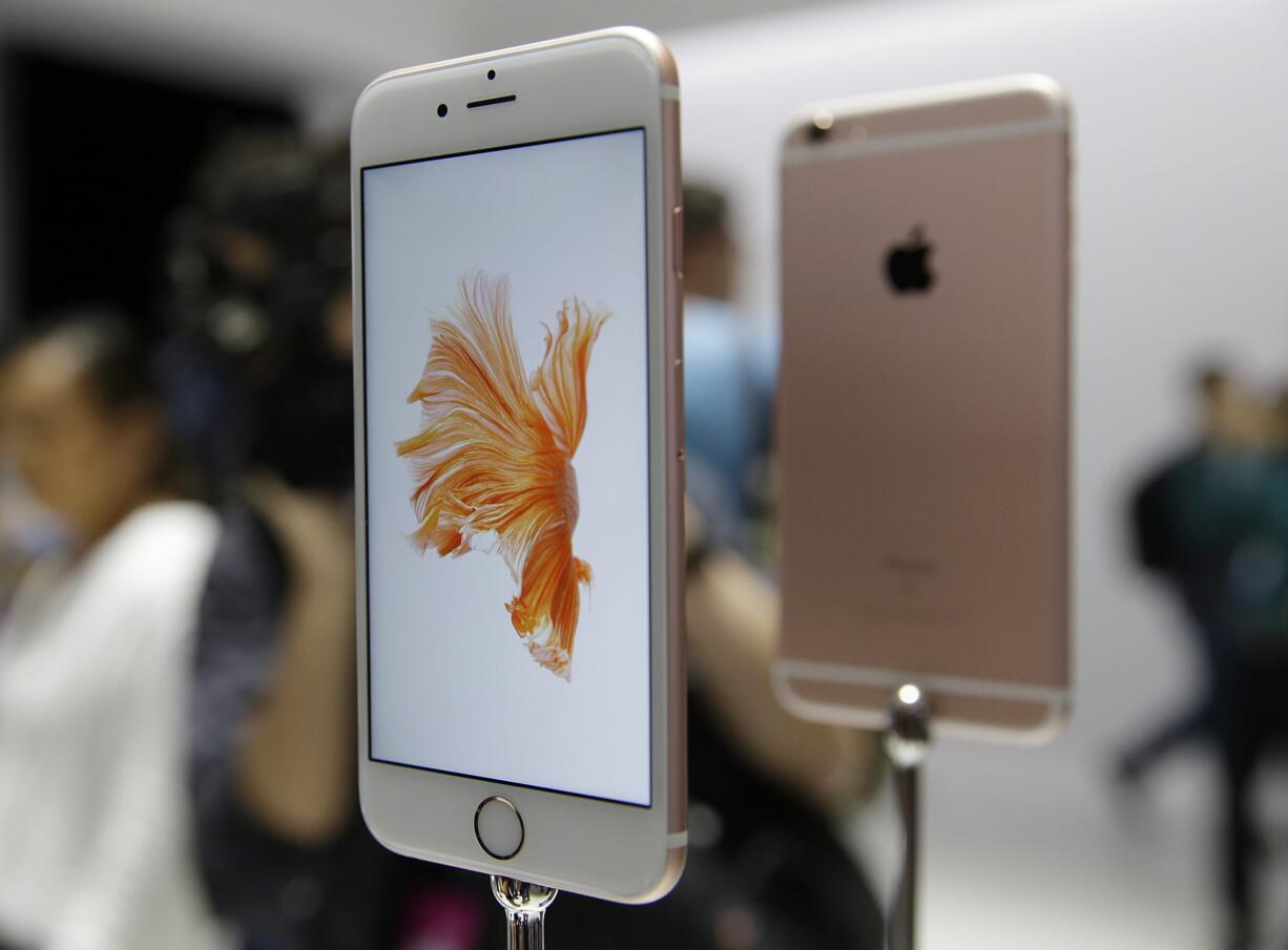 People look over the new Apple iPhone 6s models during a product display following an Apple event in San Francisco.