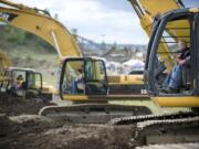 Ryder Loftis operates an excavator with help from operator Curt Spragg at Dozer Day in 2011.