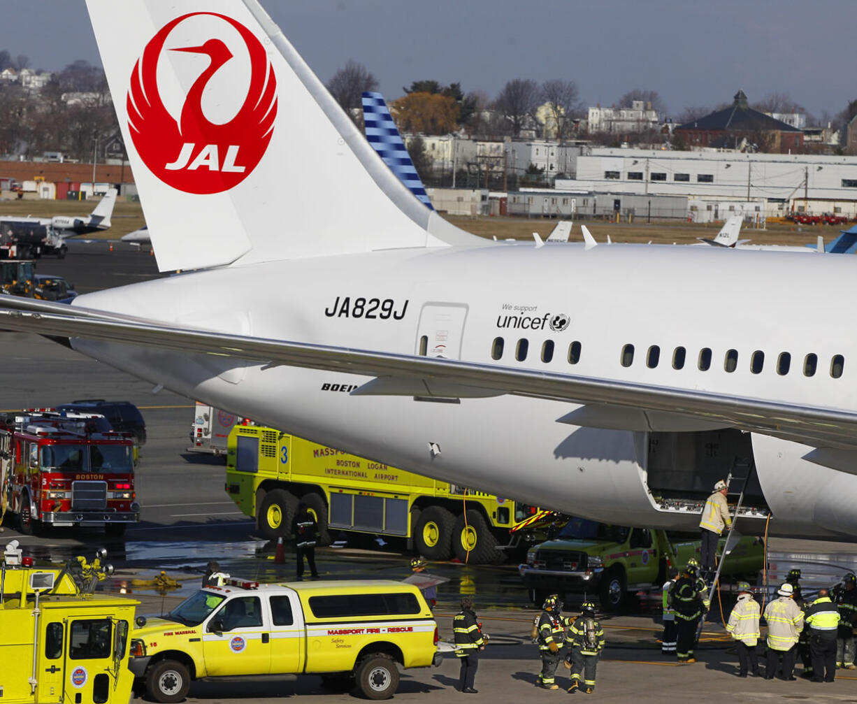 A Japan Airlines Boeing 787 jet aircraft is surrounded by emergency vehicles while parked at a terminal at Logan International Airport in Boston on Jan.