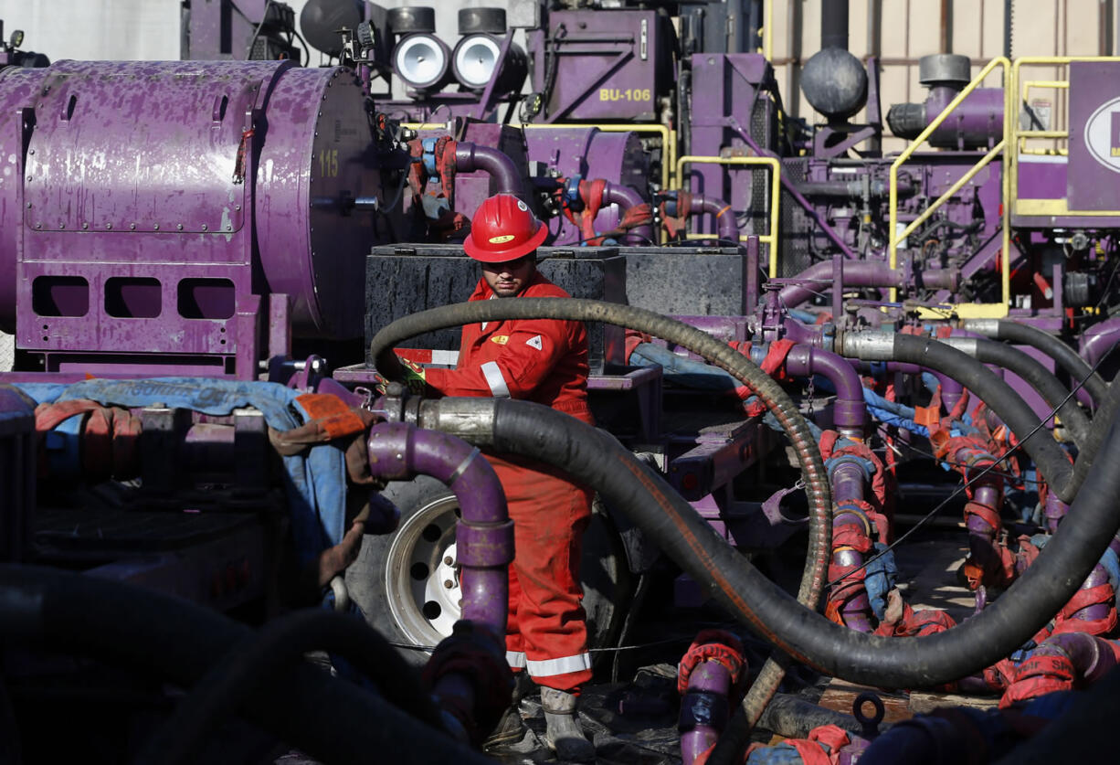 Files/Associated Press
A worker adjusts hoses during a hydraulic fracturing operation at an Encana Corp. gas well last month near Mead, Colo.