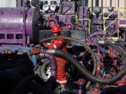 Files/Associated Press
A worker adjusts hoses during a hydraulic fracturing operation at an Encana Corp. gas well last month near Mead, Colo.