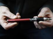 Eric Scheman holds an e-cigarette at Vape store in Chicago in September.