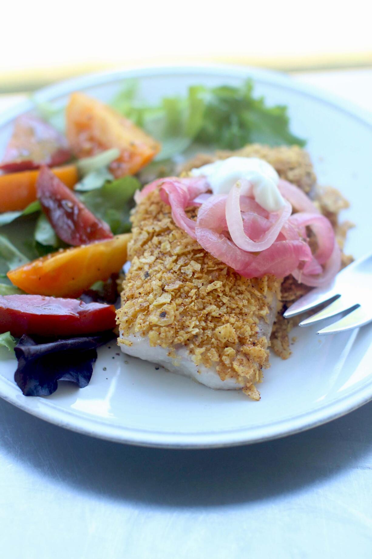 This Aug. 3, 2015 photo shows tortilla crusted tilapia with pickled red onions and crema in Concord, NH.