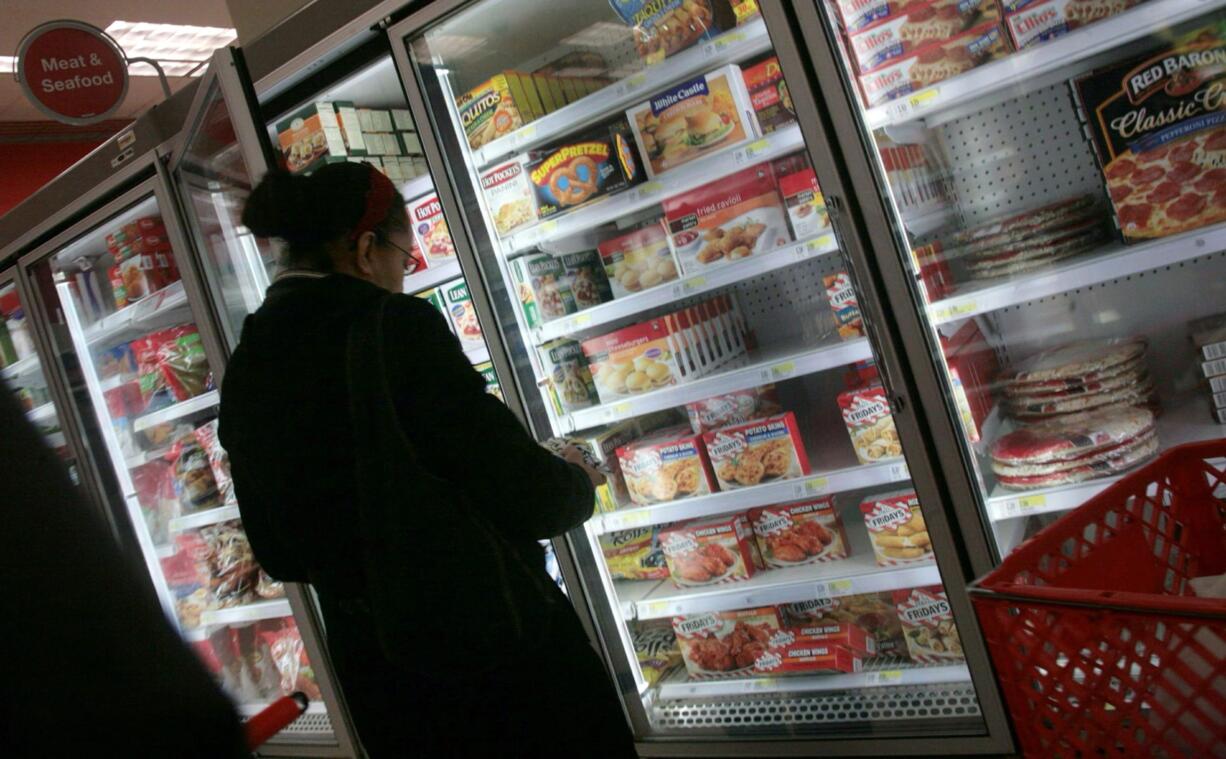 Associated Press files
A shopper looks over frozen foods selections at a supermarket in New York.